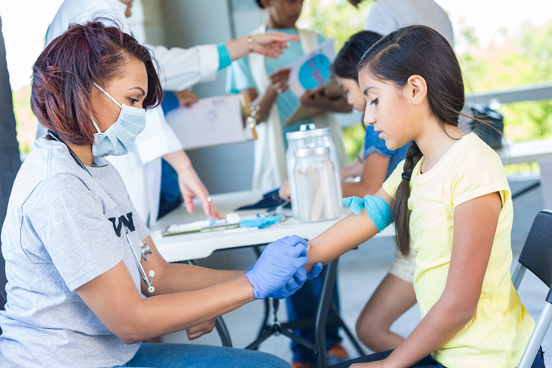 Female doctor prepares to give girl a flu shot