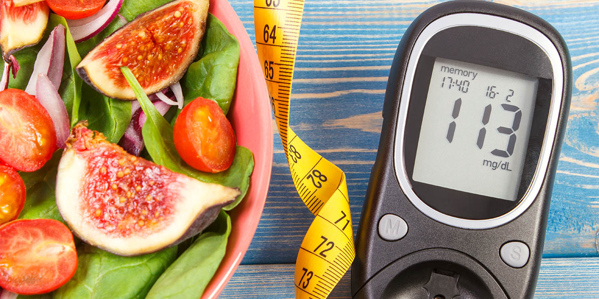 A salad, a measuring tape and a blood sugar measuring tool laying beside each other