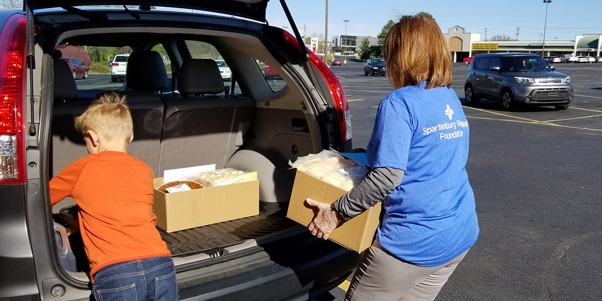 Volunteers load Thanksgiving meals for Spartanburg Regional Hospice patients into their vehicle