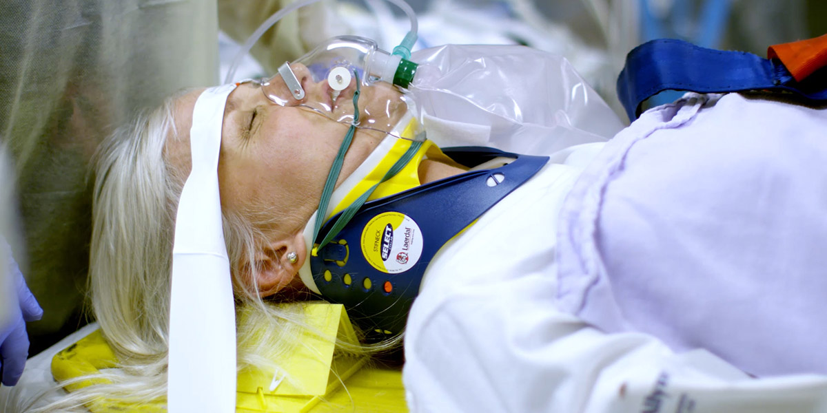 Woman laying on a gurney and being given oxygen