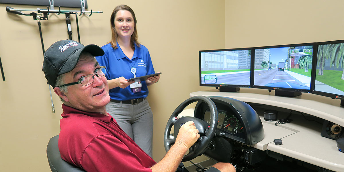 Occupational therapy patient, David Gentry, sits at the driving simulator at the Spartanburg Regional Rehabilitation Services office in the Thomas E. Hannah YMCA