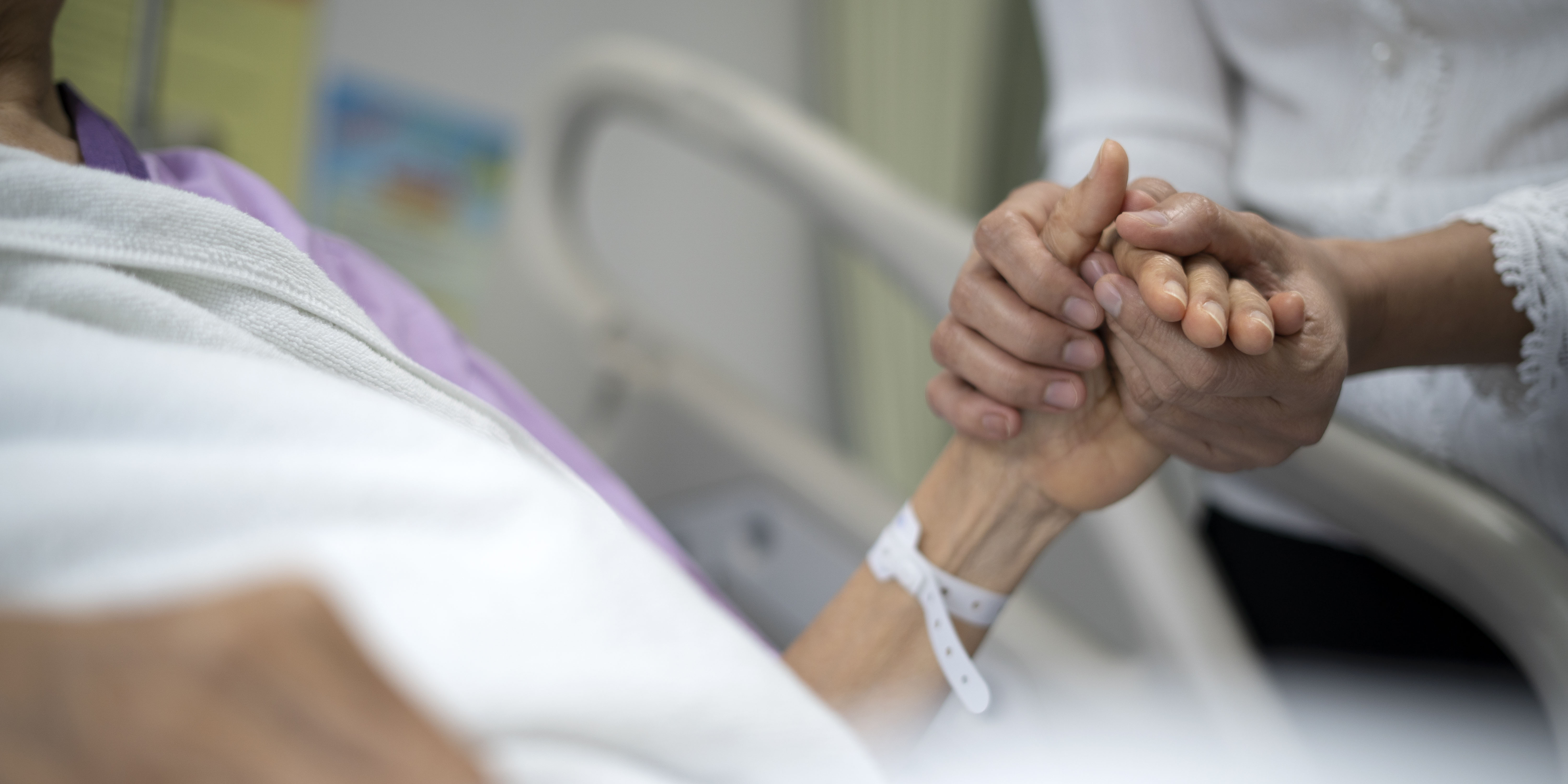 Shot of daughter encourage her mother and holding the mother's hand to sleep on the bed ​in hospital.